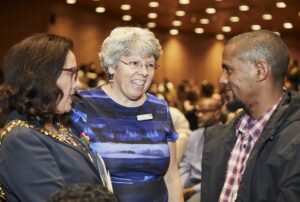 three people talking at an awards ceremony