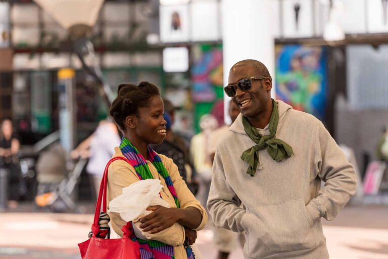 Man and woman smiling in conversation on Westway estate