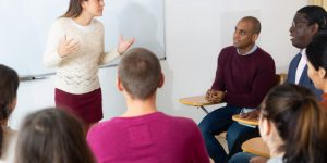 Teacher,At,University,In,Front,Of,Chalkboard,With,Multinational,Students